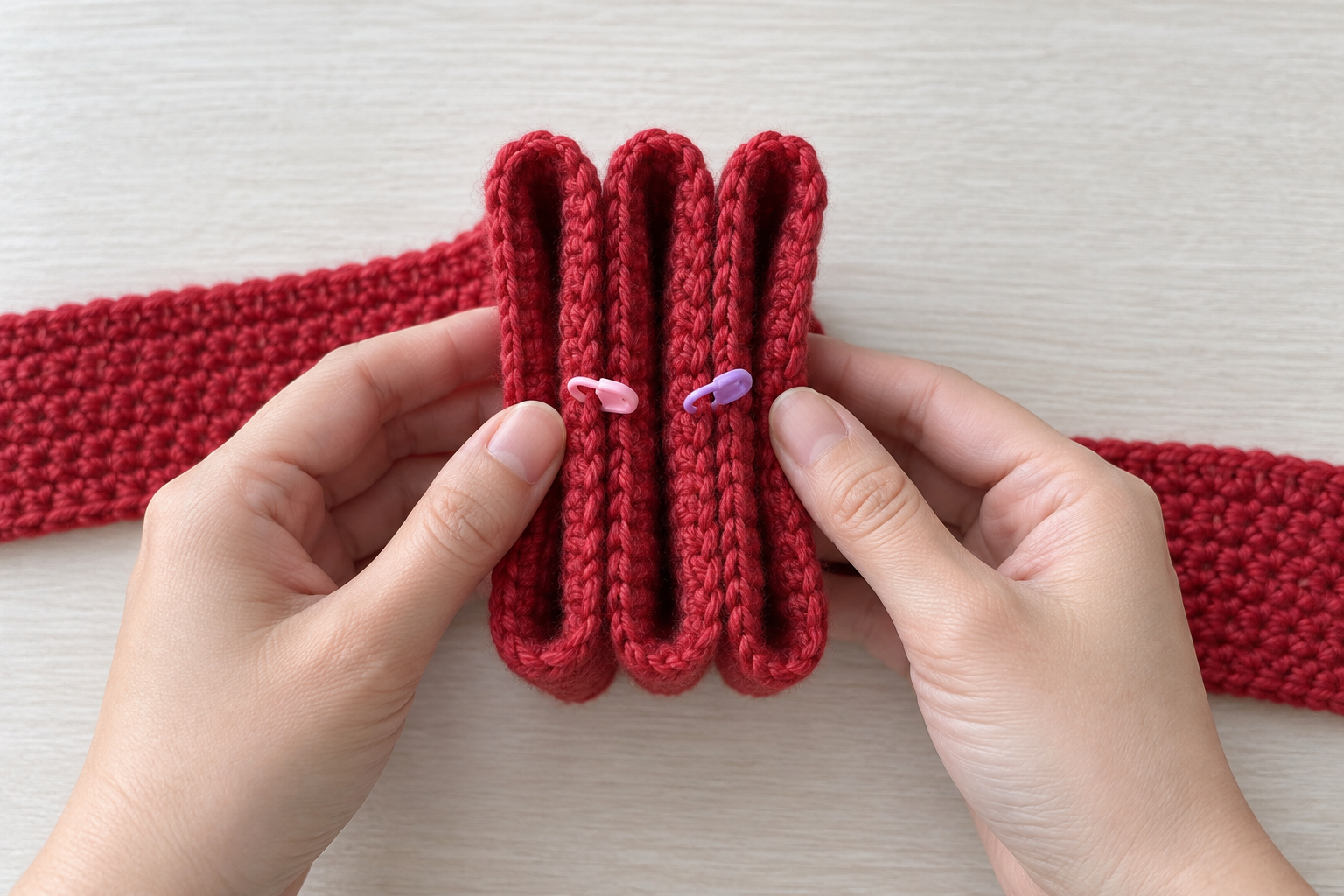 Ruby-red crochet strip folded into three aligned loops with center markers